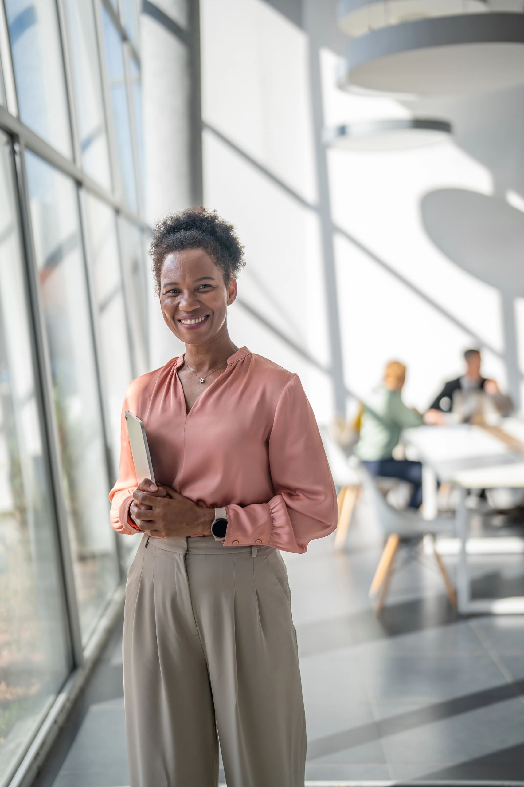Confident businesswoman holding digital tablet in modern office